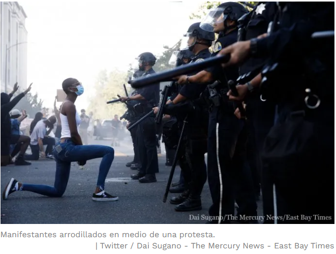 Manifestantes arrodillados frente a la policía en EEUU